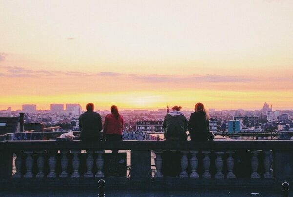 two pairs of couple sitting on concrete ground