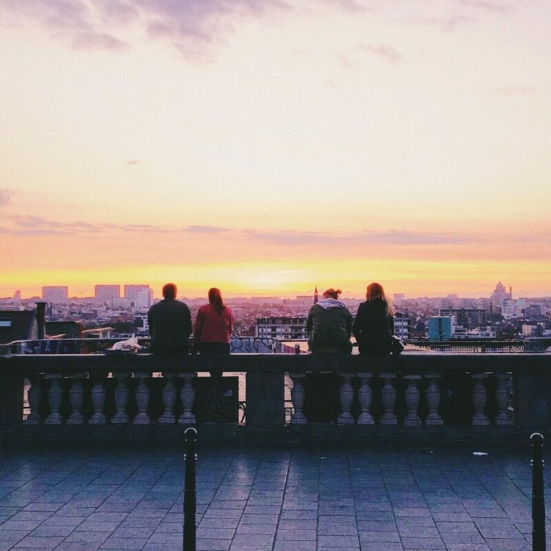 two pairs of couple sitting on concrete ground