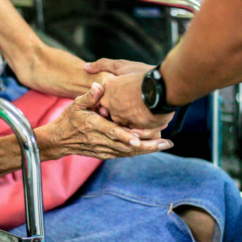 man holding hand with woman on chair